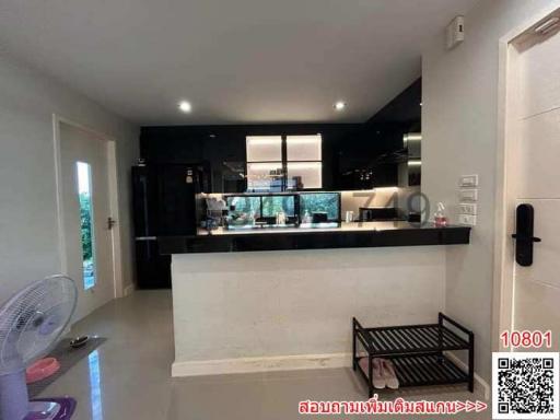 Contemporary kitchen viewed from a living space with modern furnishings and natural light