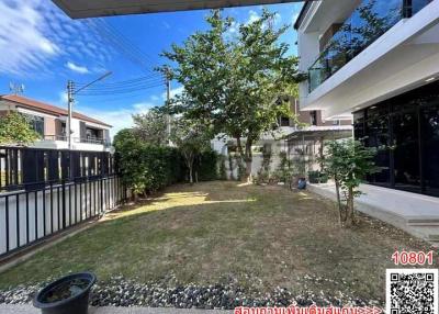 Spacious backyard garden of a residential property with green lawn and trees