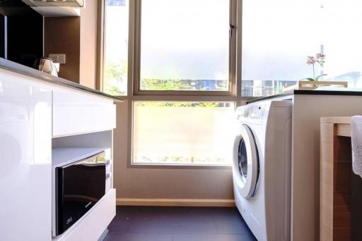 Bright laundry room with modern appliances and large window
