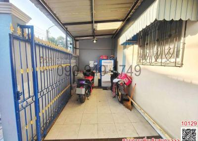 Enclosed garage space with blue gate and parked motorcycles