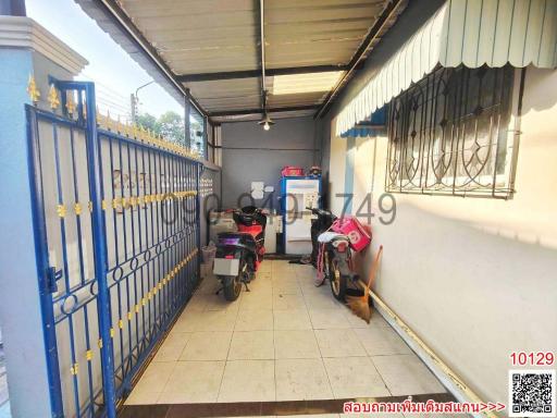 Enclosed garage space with blue gate and parked motorcycles