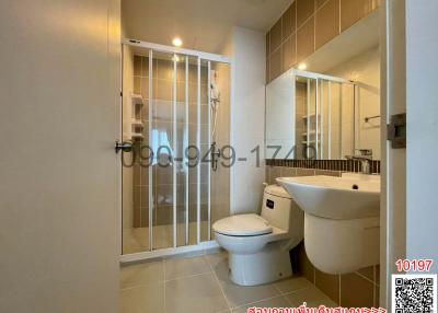 Modern bathroom interior with white fixtures and glass shower partition