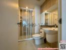 Modern bathroom interior with white fixtures and glass shower partition