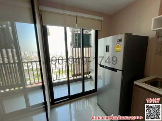 Compact kitchen with modern appliances and city view through balcony doors