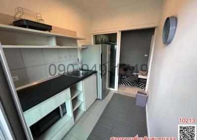 Compact modern kitchen with built-in appliances and access to a small balcony