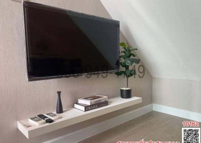 Modern living room interior with wall-mounted television and decorative shelving