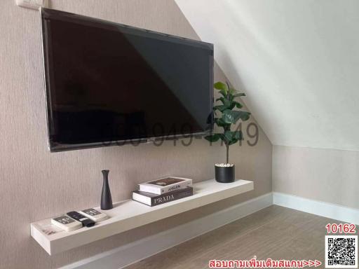 Modern living room interior with wall-mounted television and decorative shelving