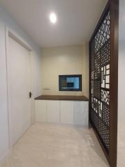 Modern entryway with decorative partition and built-in cabinetry