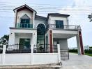 Contemporary two-story house with large windows and a balcony