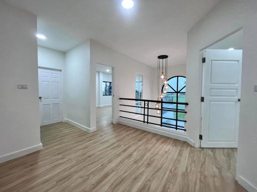 Spacious well-lit hallway with wooden flooring and modern finishes