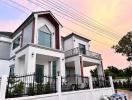 Modern two-story house with balconies at dusk