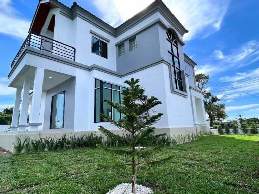 Spacious two-story house with green lawn and clear blue sky