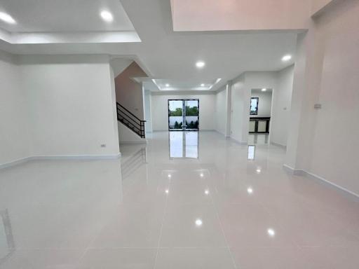 Spacious modern living area with glossy tiled flooring and multiple lighting options