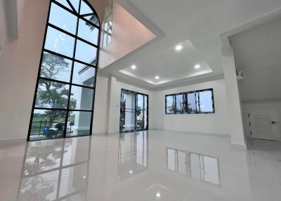 Spacious living room with large windows and high ceiling