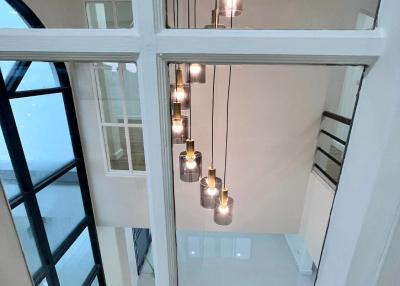 Modern home interior with vertical view of a stairwell and hanging light fixtures