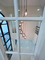 Modern home interior with vertical view of a stairwell and hanging light fixtures