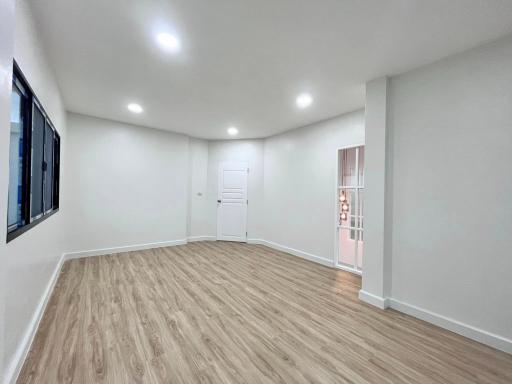 Spacious and well-lit living room with wooden flooring