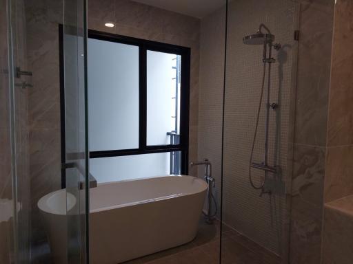 Modern bathroom with a bathtub, glass shower, and a frosted window