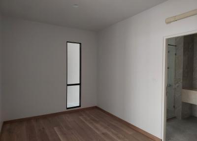 Unfurnished bedroom with wooden floor and attached bathroom
