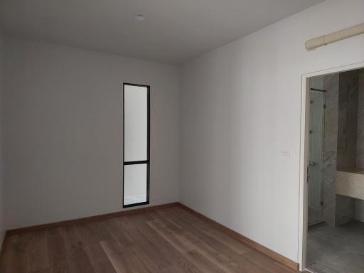 Unfurnished bedroom with wooden floor and attached bathroom