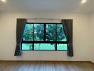 Bright bedroom with a large window and a view of greenery