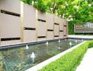 Tranquil outdoor patio area with a water feature and lush greenery