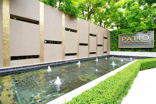 Tranquil outdoor patio area with a water feature and lush greenery