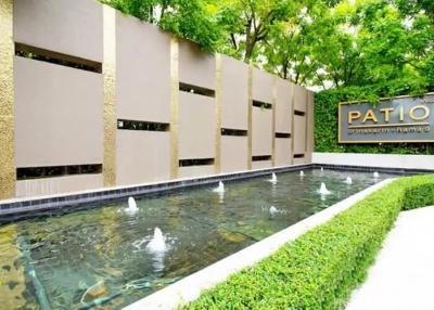 Tranquil outdoor patio area with a water feature and lush greenery