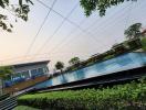 Spacious outdoor swimming pool with surrounding greenery and lounging chairs