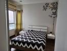Cozy furnished bedroom with a large window and decorative wall art
