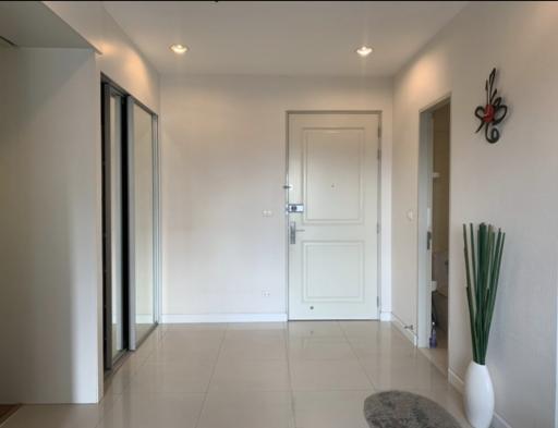 Bright and modern entryway with white walls and tiled flooring