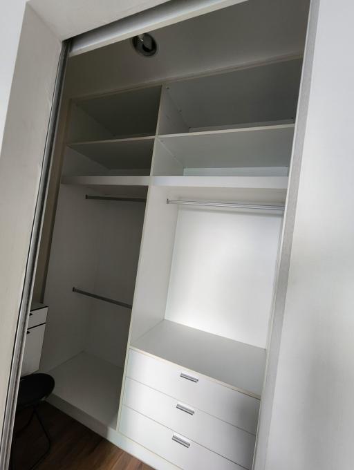 Built-in bedroom closet with open doors showcasing shelves and drawers