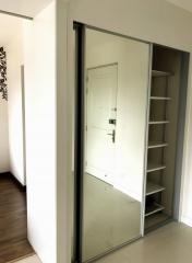 Modern entryway with large mirror sliding door and built-in shelving