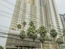 Tall modern residential building with palm trees in the foreground