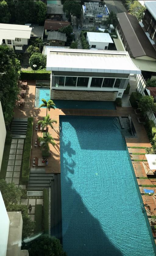 Aerial view of a building complex with a large swimming pool