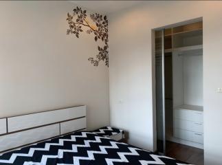 Modern bedroom with decorative wall art and mirrored closet doors