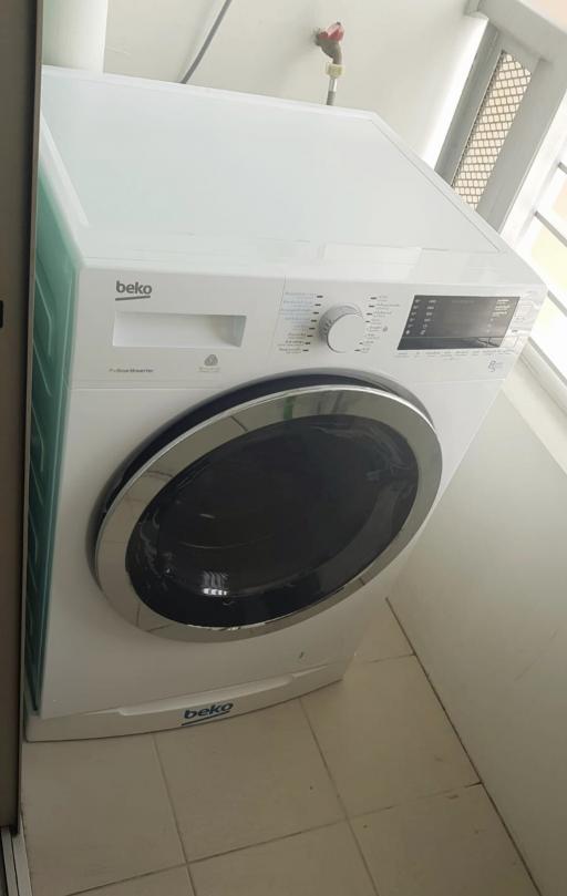 Modern Beko washing machine in a bright laundry area
