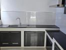 Modern kitchen with stainless steel appliances and white tiles