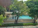 Inviting outdoor pool area surrounded by lush greenery