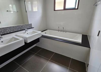 Modern bathroom with dual sinks and a bathtub