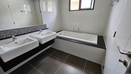 Modern bathroom with dual sinks and a bathtub