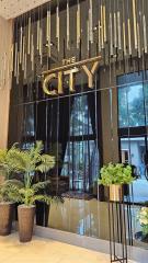 Elegant building lobby entrance with decorative hanging lights and lush greenery