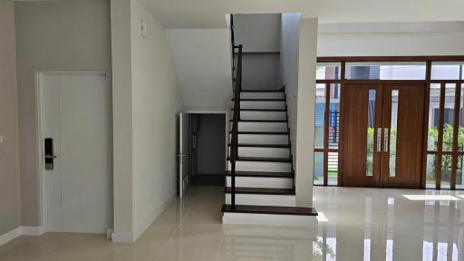 Spacious interior with staircase and gleaming tiled floor