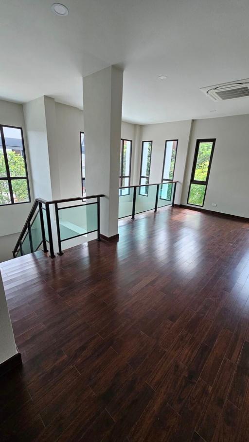 Spacious upper level living area with hardwood flooring and large windows