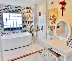 Elegant bathroom with freestanding tub and artistic wall tiles