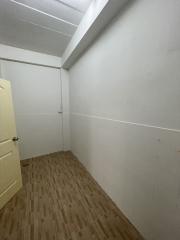 Compact room with wooden flooring and white walls