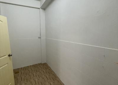 Compact room with wooden flooring and white walls