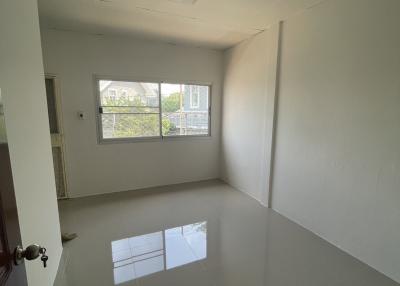 Bright empty bedroom with glossy tiled flooring and a large window