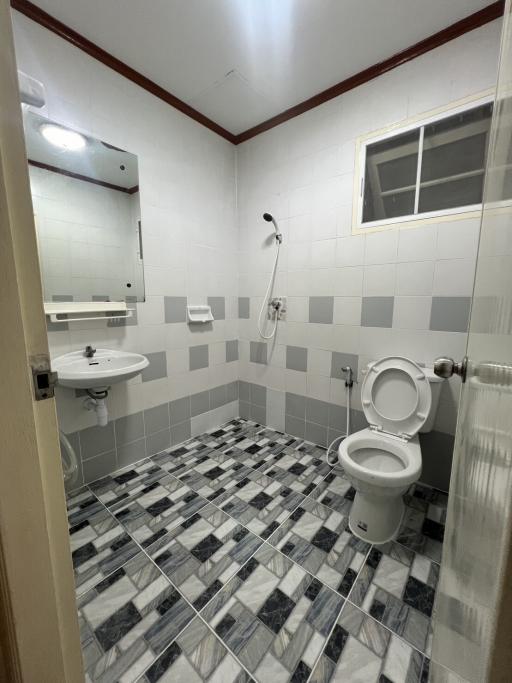 Compact tiled bathroom with white fixtures