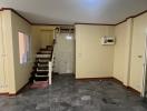 Spacious living area with stairway and air conditioning unit